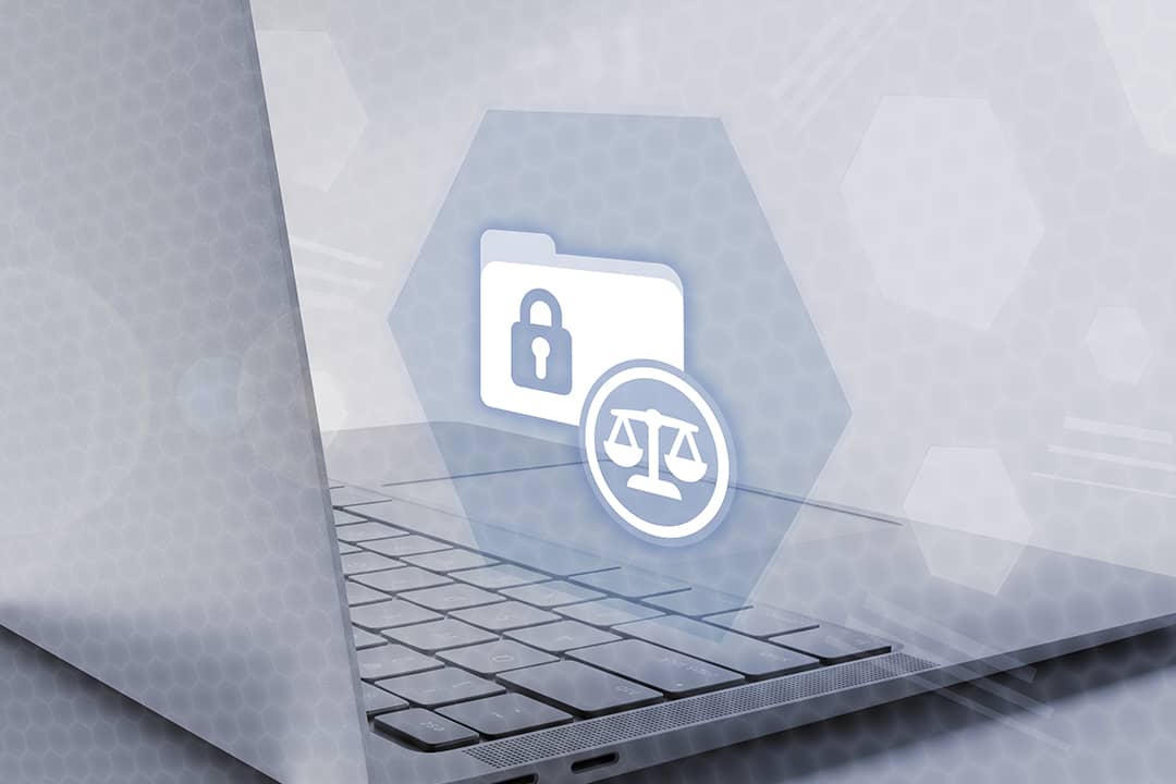 A laptop showing a holograph of secured folder and justice symbol icons, depicting a concept of legal compliance and data protection.